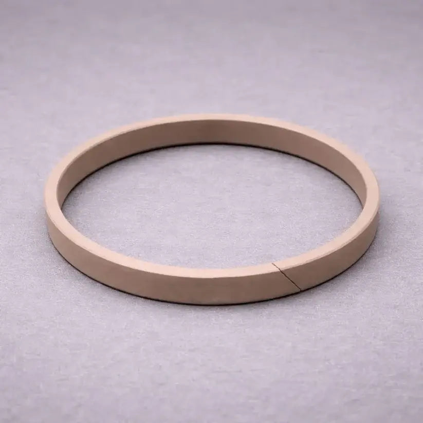 Split wear band (guide ring) for hydraulic and pneumatic cylinder piston guidance, preventing metal-to-metal contact and bore scoring in industrial applications.