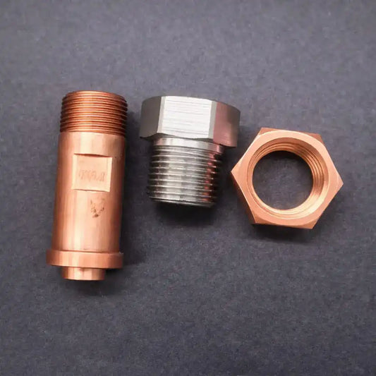 Precision-machined copper and stainless steel adaptors with a copper hex nut for industrial fittings and OEM assemblies.