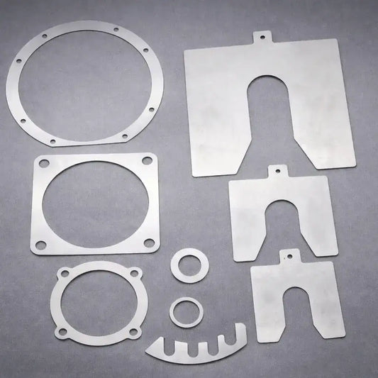 Custom laser cut metal shims in circular, slotted, and square profiles for industrial alignment and gap adjustment.