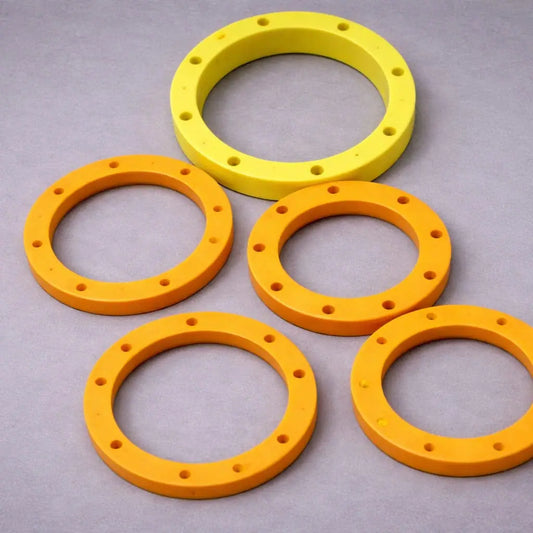 Plastic ring segments with bolt-hole pattern for segmented wear rings and large-diameter industrial liner assemblies.