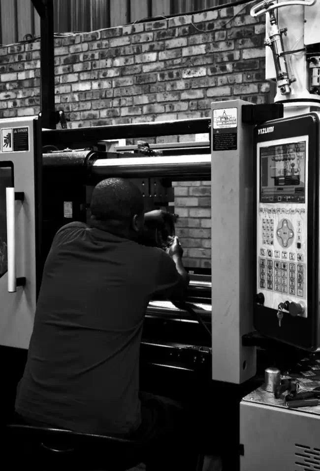 Kaybin technician performing precision setup on a Yizumi injection molding machine for industrial seal manufacturing in South Africa