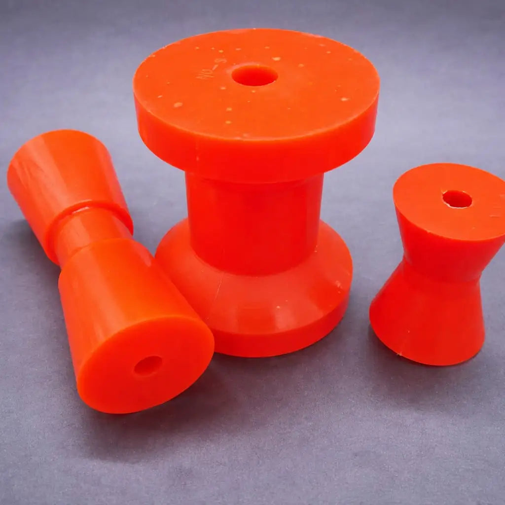 Red polyurethane rollers in conical and spool configurations on a neutral background.